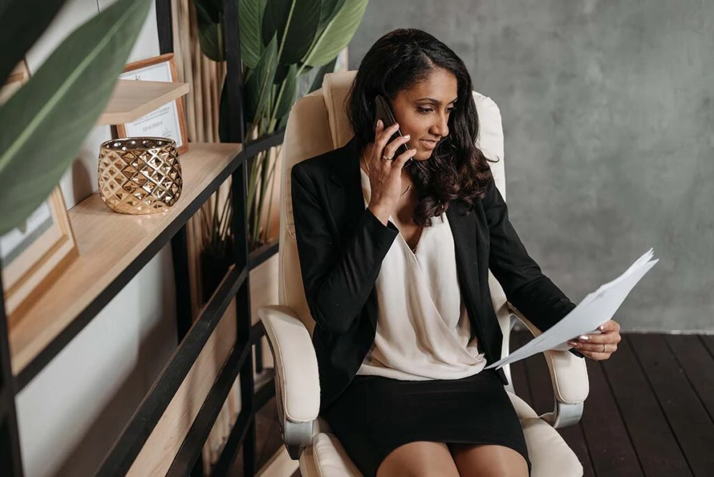 Female Business owner on Phone While Looking Over Paperwork